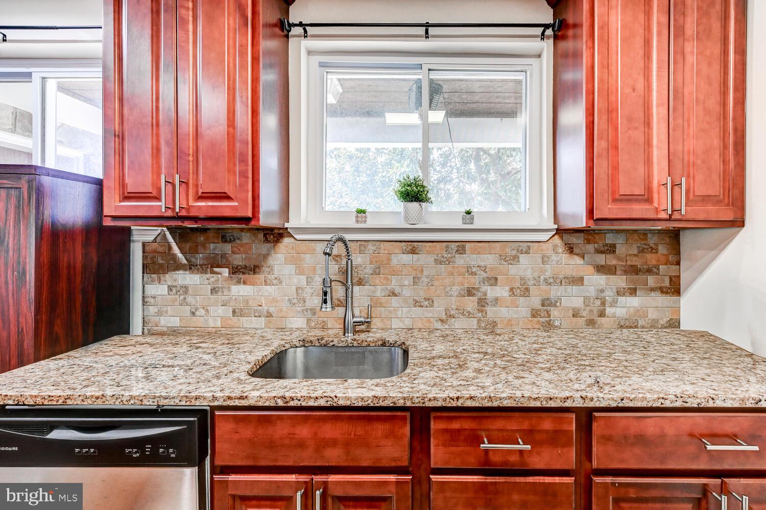 6420 Kenwood Avenue Rosedale, MD 21237 - Photo 9 of 22 a kitchen with granite countertop wooden cabinets a sink and a window