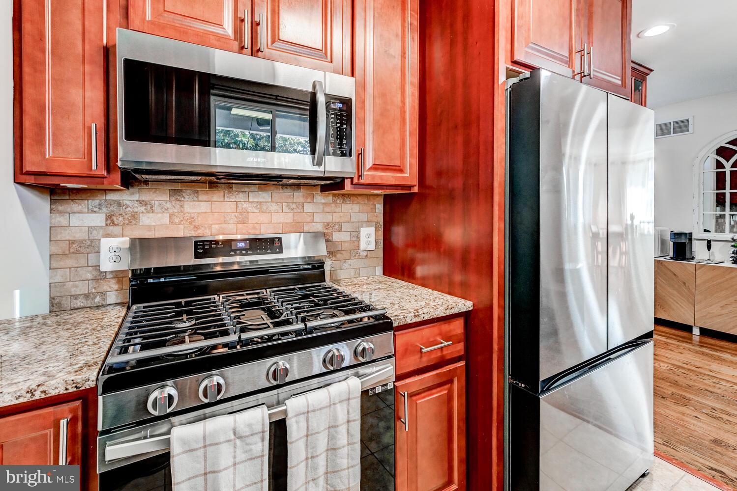 6420 Kenwood Avenue Rosedale, MD 21237 - Photo 10 of 22 a kitchen with stainless steel appliances granite countertop a stove microwave and refrigerator