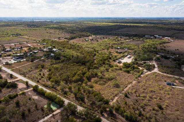 an aerial view of residential houses with outdoor space and ocean view