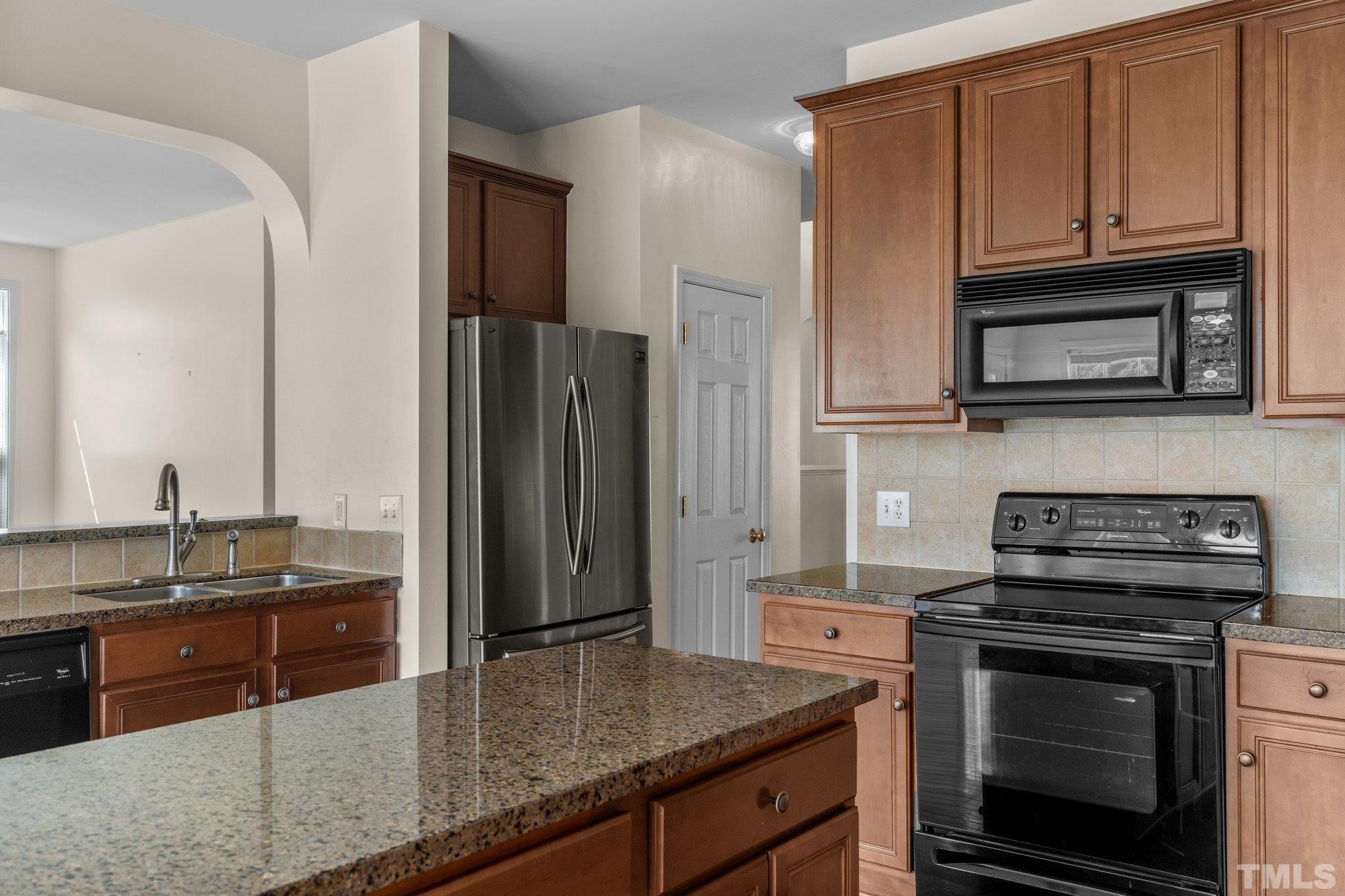 6010 Clarks Fork Drive Raleigh, NC 27616 - Photo 15 of 40 a kitchen with granite countertop a stove microwave and refrigerator