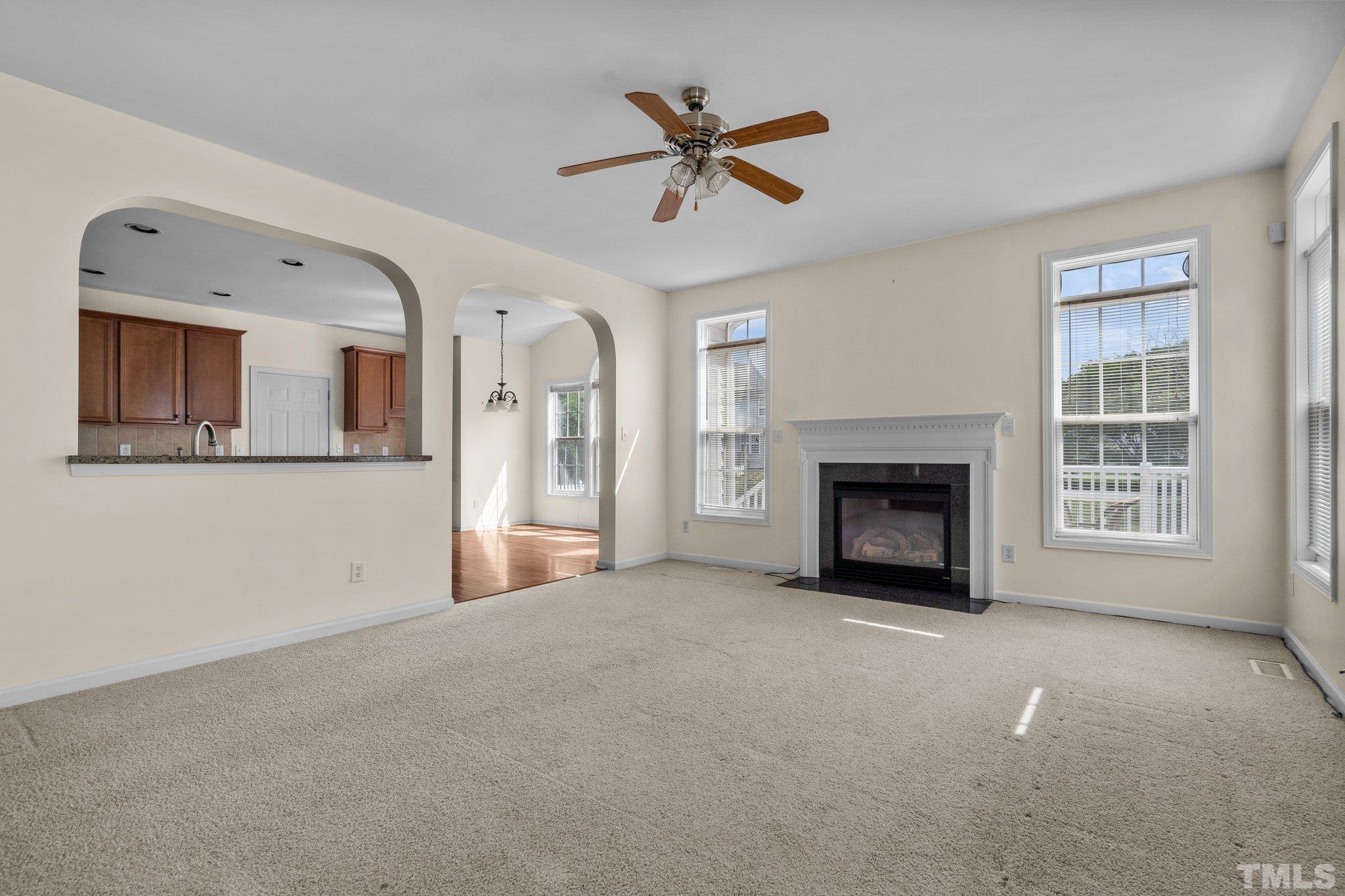 6010 Clarks Fork Drive Raleigh, NC 27616 - Photo 19 of 40 a view of a livingroom with a fireplace a ceiling fan and windows