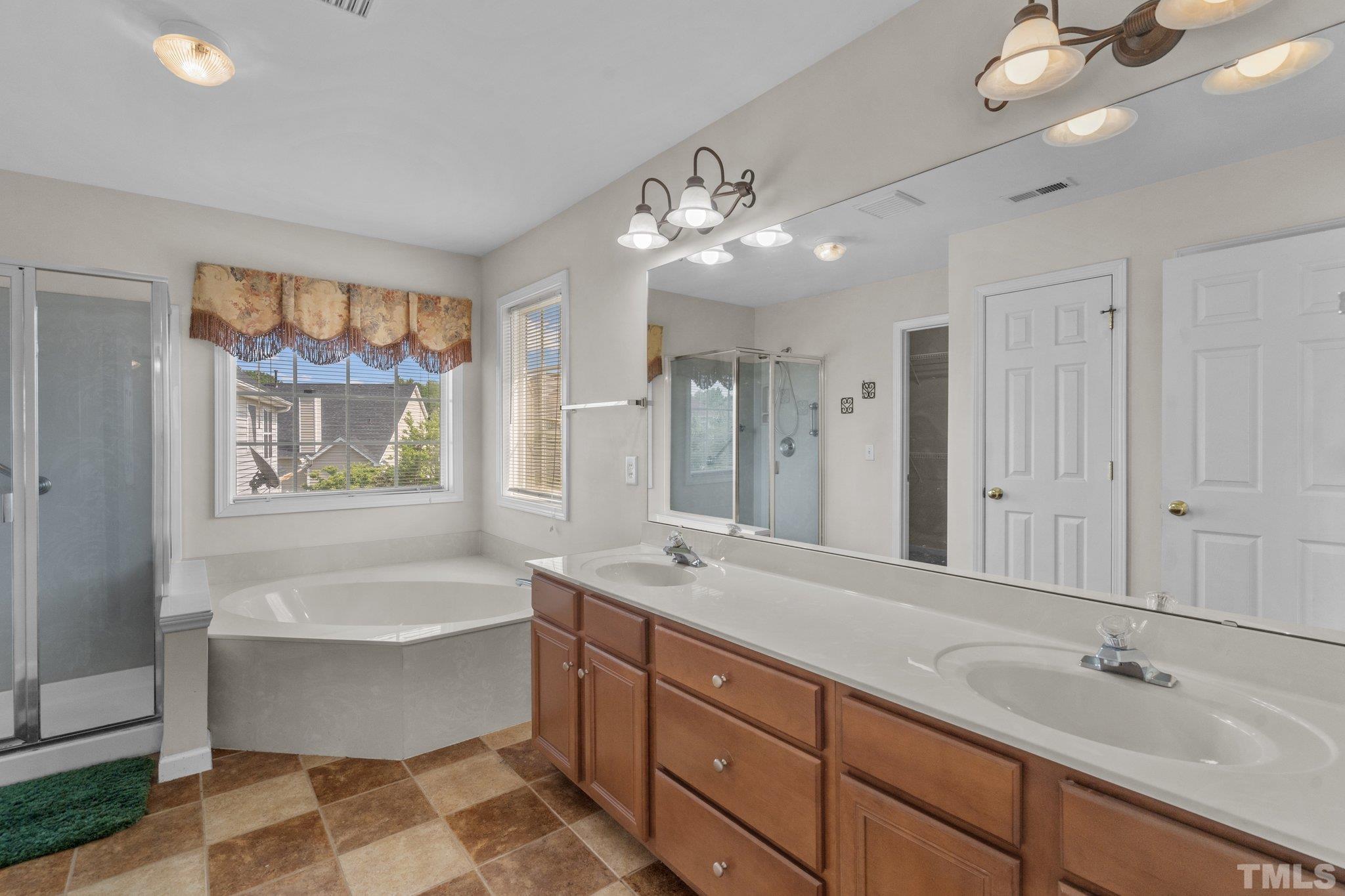 6010 Clarks Fork Drive Raleigh, NC 27616 - Photo 25 of 40 a spacious bathroom with a large tub shower and sink