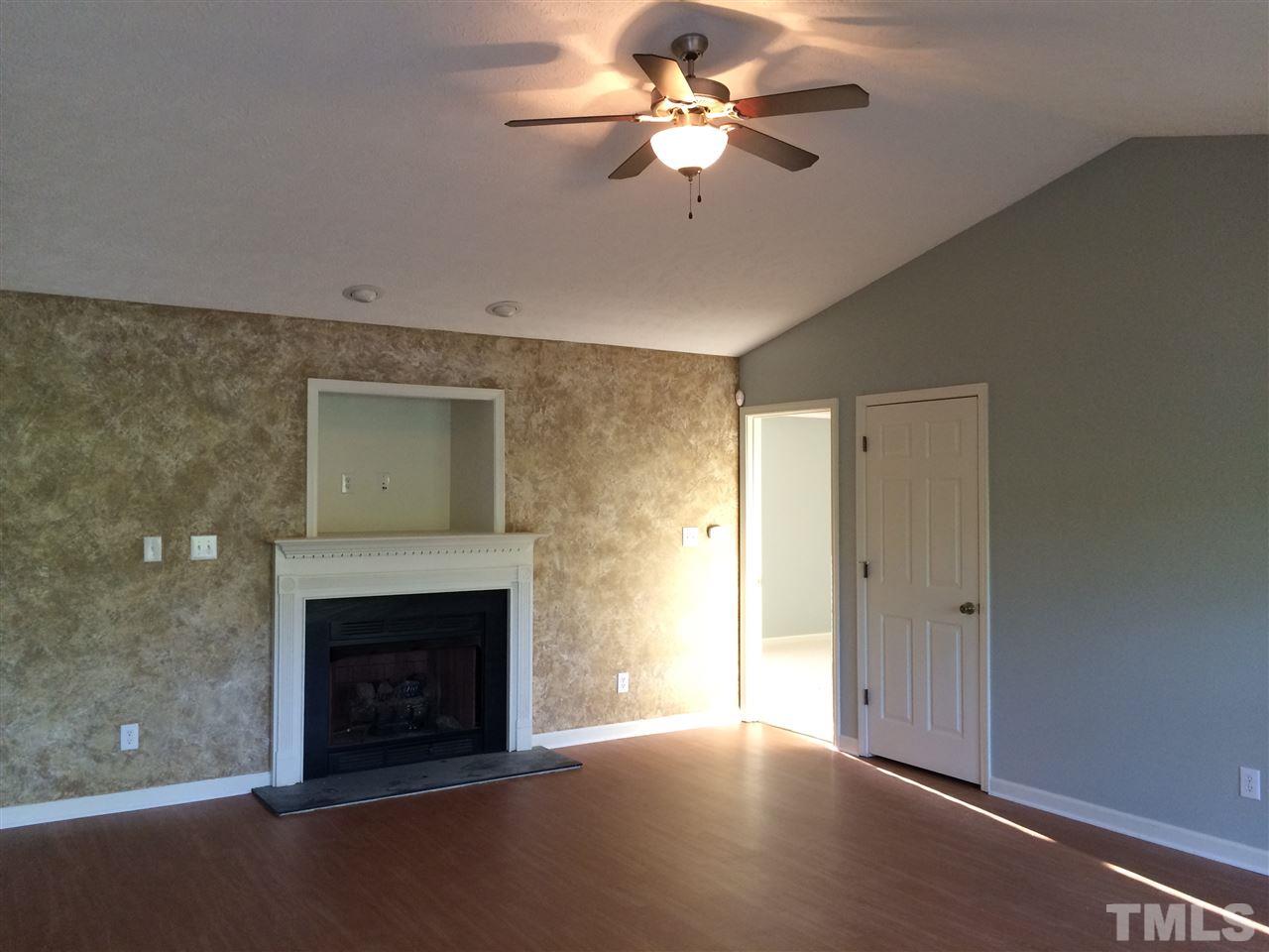2008 Tingen Road Lillington, NC 27546 - Photo 3 of 25 a view of a livingroom with a fireplace a ceiling fan and hardwood floor