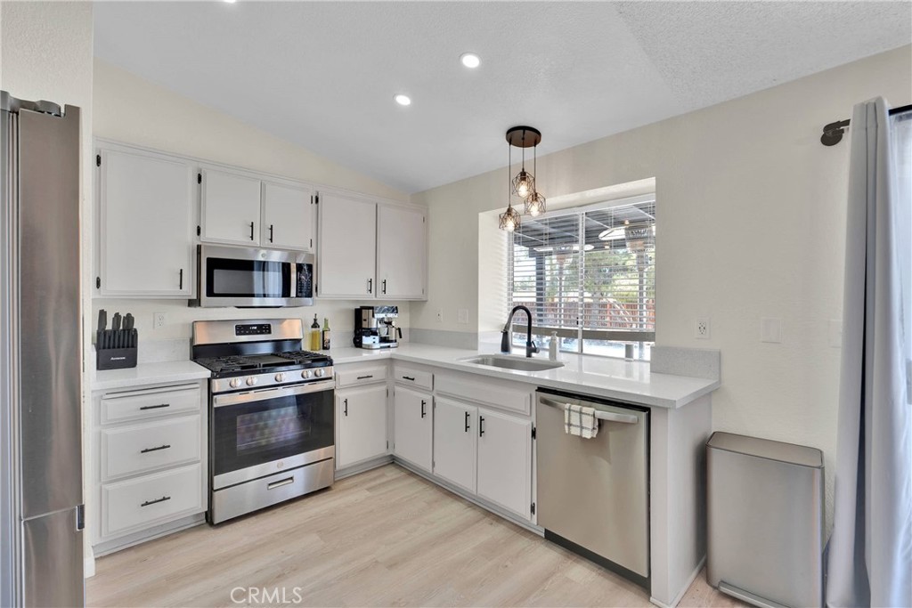 14769 Nanticoke Road Apple Valley, CA 92307 - Photo 13 of 30 a kitchen with granite countertop white cabinets and white appliances