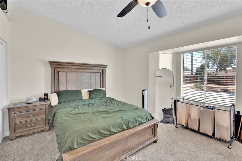 14769 Nanticoke Road Apple Valley, CA 92307 - Photo 21 of 30 a bedroom with a bed a dresser and a window