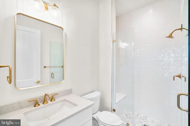 a bathroom with a sink vanity mirror and toilet