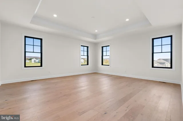 an empty room with windows and wooden floor