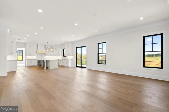 a view of empty room with kitchen and window