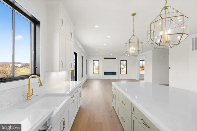 a view of a kitchen with a sink and large windows