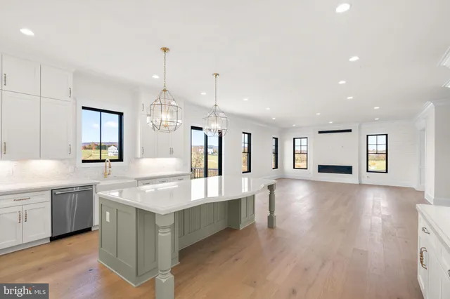 a large kitchen with sink and dishwasher with wooden floor
