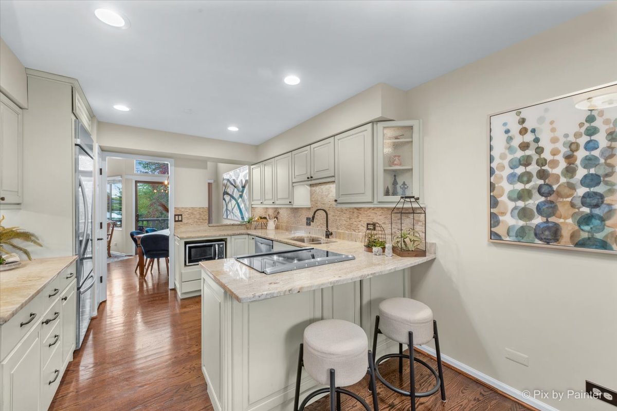 831 Shoreline Road Lake Barrington, IL 60010 - Photo 13 of 47 a kitchen with stainless steel appliances granite countertop a stove a sink dishwasher and a dining table with wooden floor