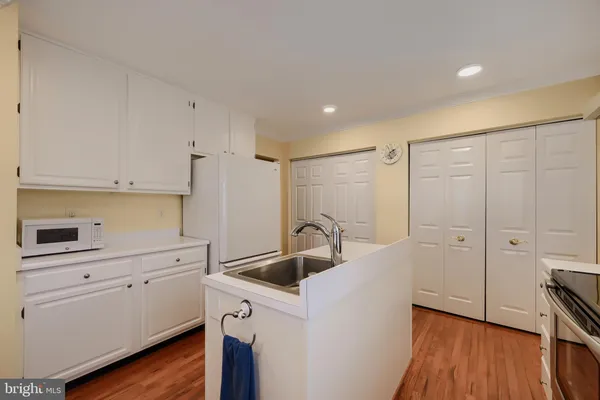 a kitchen with a sink a refrigerator and cabinets