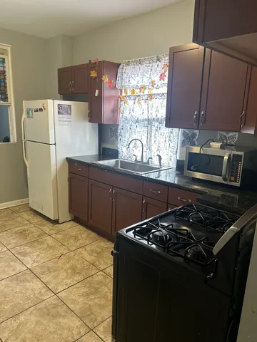 a kitchen with granite countertop a refrigerator stove and sink
