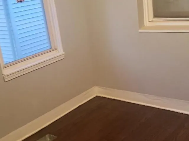 a view of a small space with wooden floor and a window