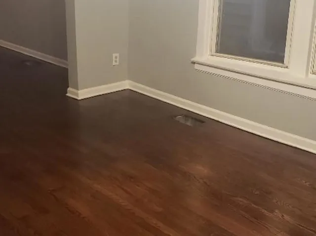 a view of a small space with wooden floor and a window