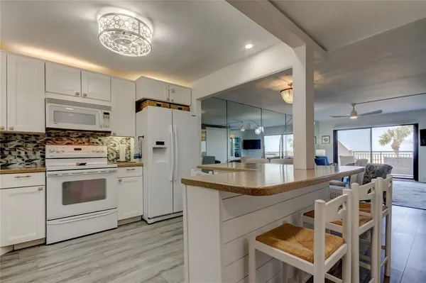 a kitchen with kitchen island a stove a refrigerator and a stove