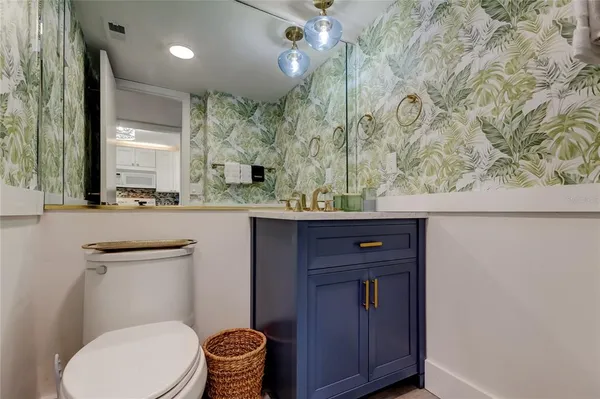 a bathroom with a granite countertop toilet sink and mirror
