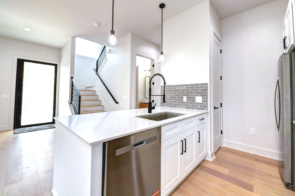 4424 Hank Avenue, Unit 2 Austin, TX 78745 - Photo 6 of 11 A sleek island kitchen featuring a convenient dishwasher and premium hardwood floors.