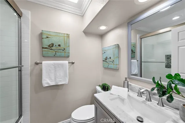 a bathroom with a granite countertop sink mirror vanity and toilet