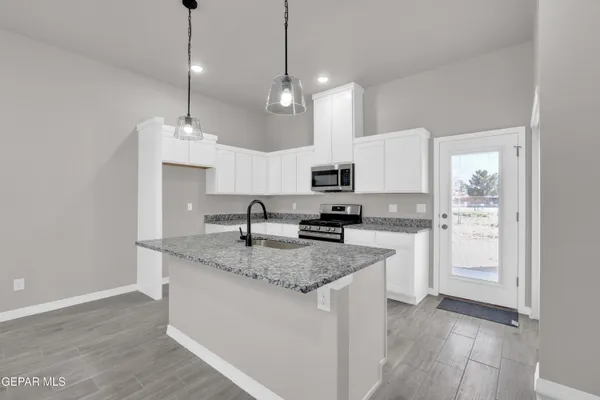 a kitchen with stainless steel appliances a sink dishwasher a stove and a microwave oven with wooden floor