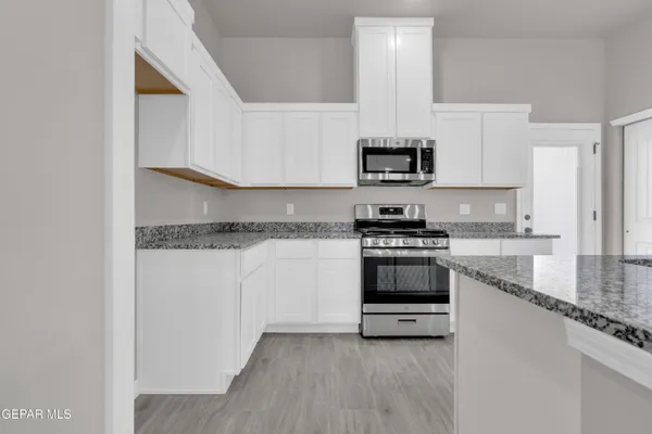 a kitchen with white cabinets and sink