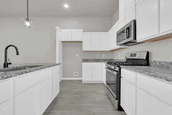 a kitchen with stainless steel appliances granite countertop white cabinets and a granite counter tops
