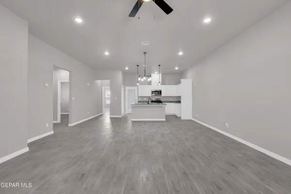 a view of an empty room and kitchen view