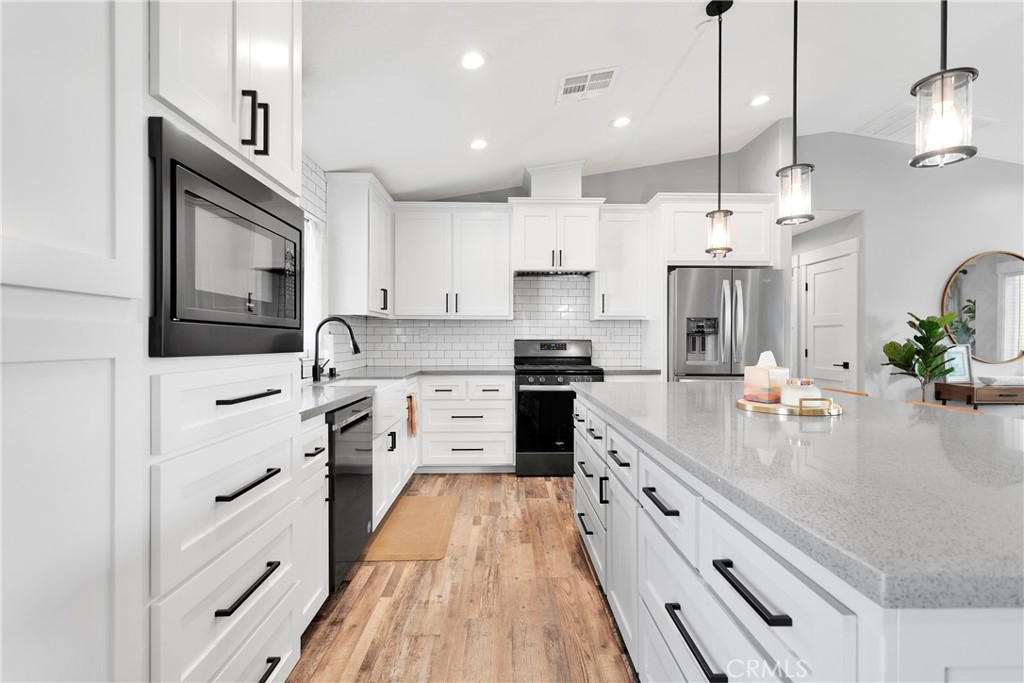 13968 Chogan Road Apple Valley, CA 92307 - Photo 12 of 35 a kitchen with stainless steel appliances a refrigerator sink and white cabinets