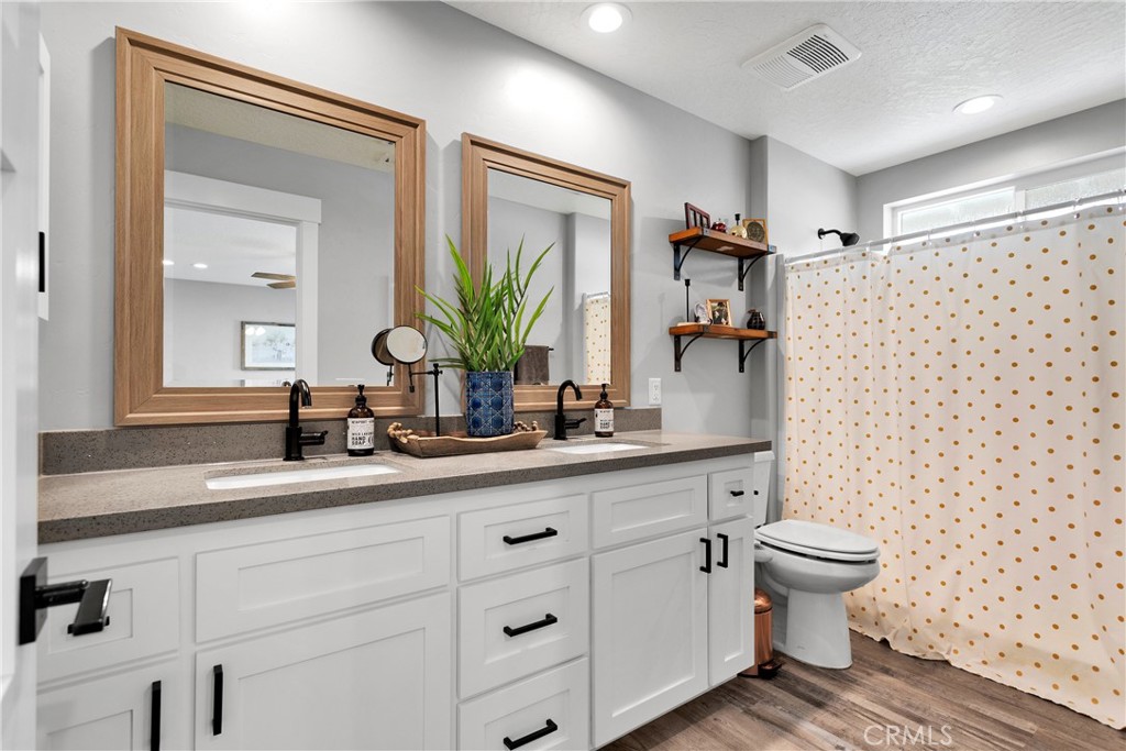 13968 Chogan Road Apple Valley, CA 92307 - Photo 17 of 35 a bathroom with a double vanity sink toilet and shower