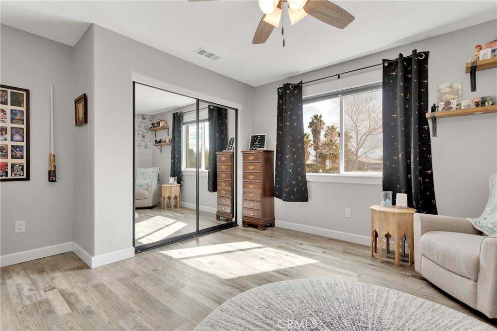 13968 Chogan Road Apple Valley, CA 92307 - Photo 18 of 35 a spacious bedroom with a large bed and a couch