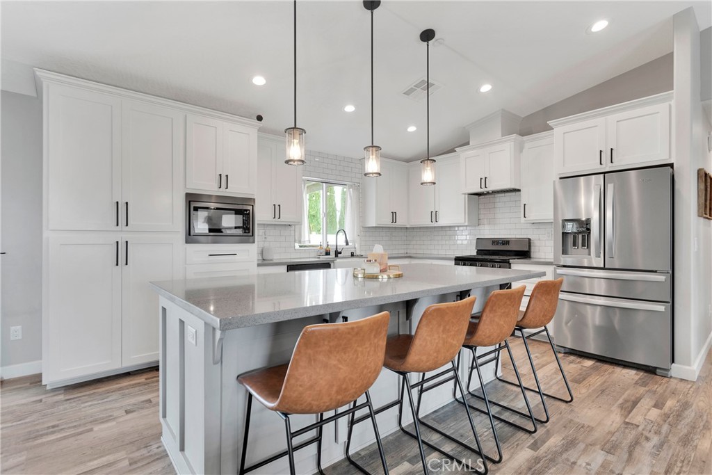 13968 Chogan Road Apple Valley, CA 92307 - Photo 10 of 35 a kitchen with stainless steel appliances granite countertop a stove a refrigerator a kitchen island a sink and a refrigerator