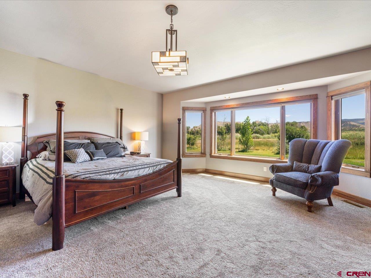 20784 6840th Road Montrose, CO 81403 - Photo 20 of 35 a bedroom with a bed and a chandelier