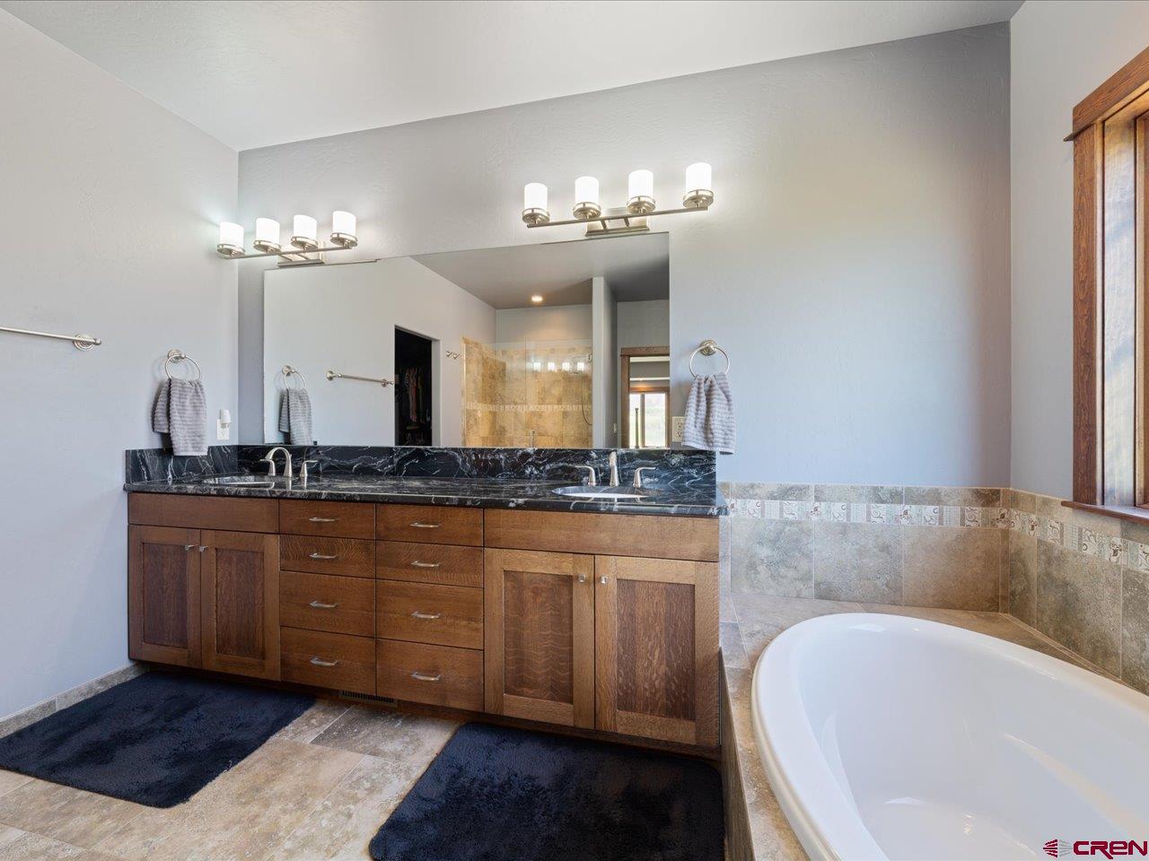 20784 6840th Road Montrose, CO 81403 - Photo 26 of 35 a spacious bathroom with a granite countertop bathtub a sink and a mirror