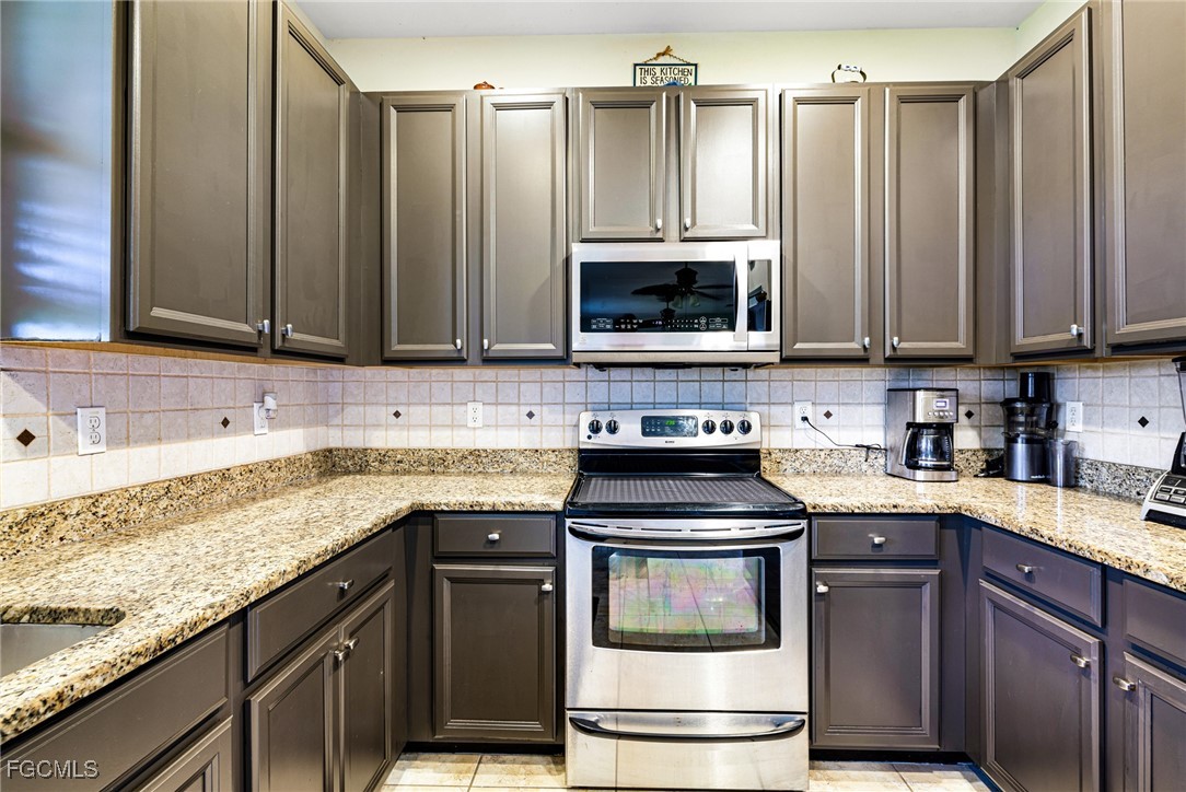 8657 Sumner Avenue Fort Myers, FL 33908 - Photo 7 of 29 a kitchen with granite countertop a stove top oven cabinetry and granite counter tops