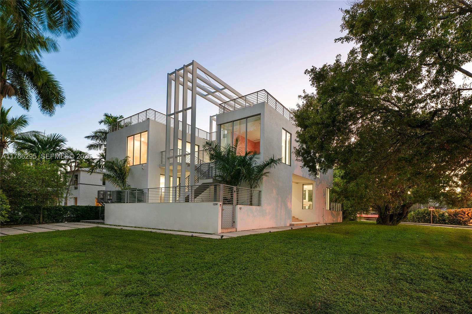 1250 North Venetian Way Miami, FL 33139 - Photo 4 of 61 a view of a white house next to a yard with palm trees