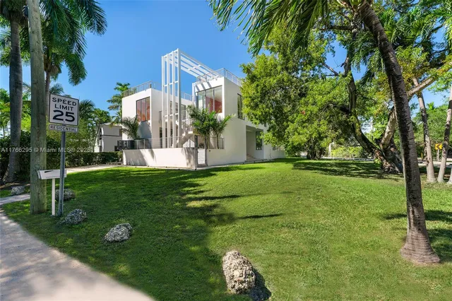 a view of a house with a yard and a large tree