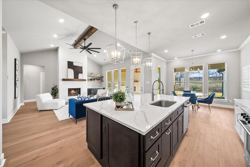 6421 Starlight Ranch Road Godley, TX 76044 - Photo 14 of 39 a large kitchen with a counter space a sink appliances and living room view