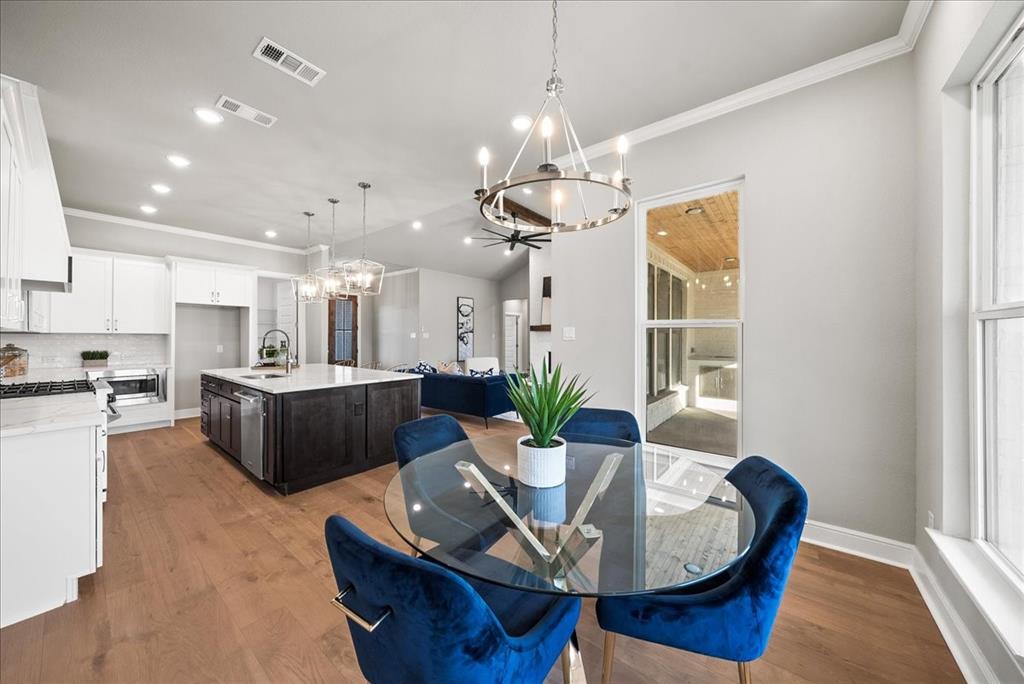 6421 Starlight Ranch Road Godley, TX 76044 - Photo 16 of 39 a living room with kitchen island furniture and a chandelier