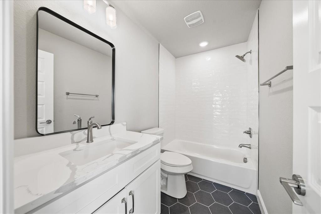 6421 Starlight Ranch Road Godley, TX 76044 - Photo 30 of 39 a bathroom with a bathtub shower sink vanity and a toilet