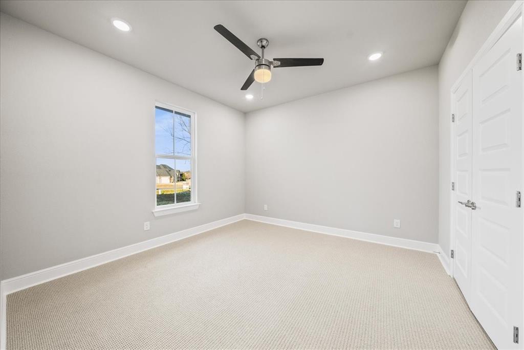 6421 Starlight Ranch Road Godley, TX 76044 - Photo 32 of 39 an empty room with a window and a ceiling fan