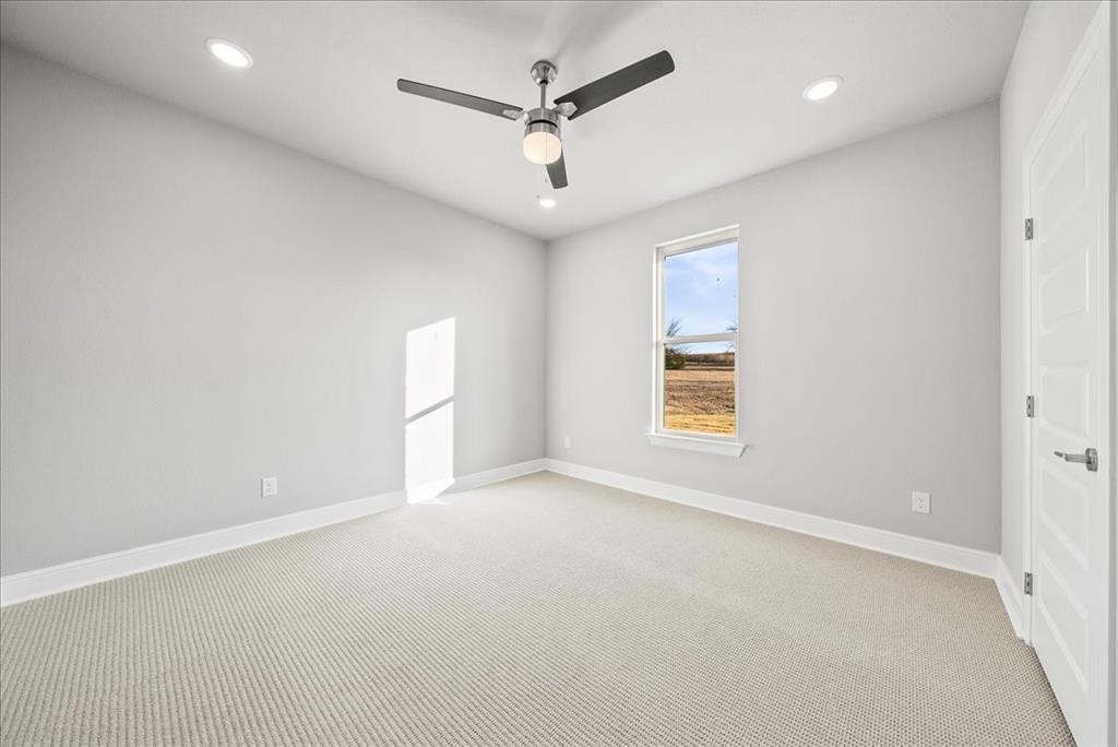6421 Starlight Ranch Road Godley, TX 76044 - Photo 35 of 39 an empty room with a window and a ceiling fan