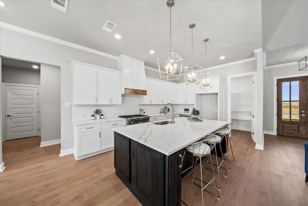 6421 Starlight Ranch Road Godley, TX 76044 - Photo 9 of 39 a large kitchen with stainless steel appliances a stove a sink a refrigerator a kitchen island a table and chairs