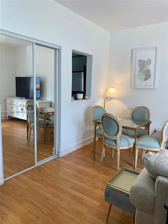 a living room with furniture a flat screen tv and kitchen view