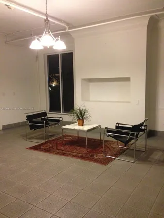 a living room with a table and a chandelier