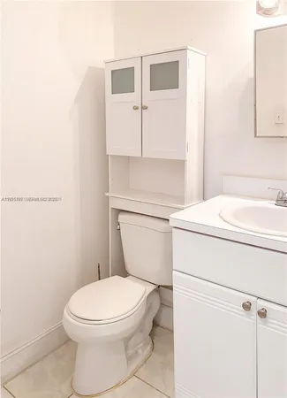 a white toilet sitting next to a bathroom sink