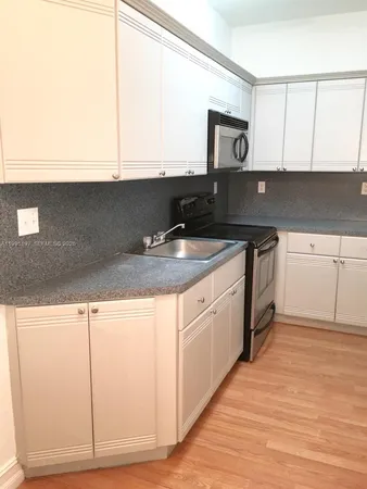 a kitchen with stainless steel appliances granite countertop a sink and a stove