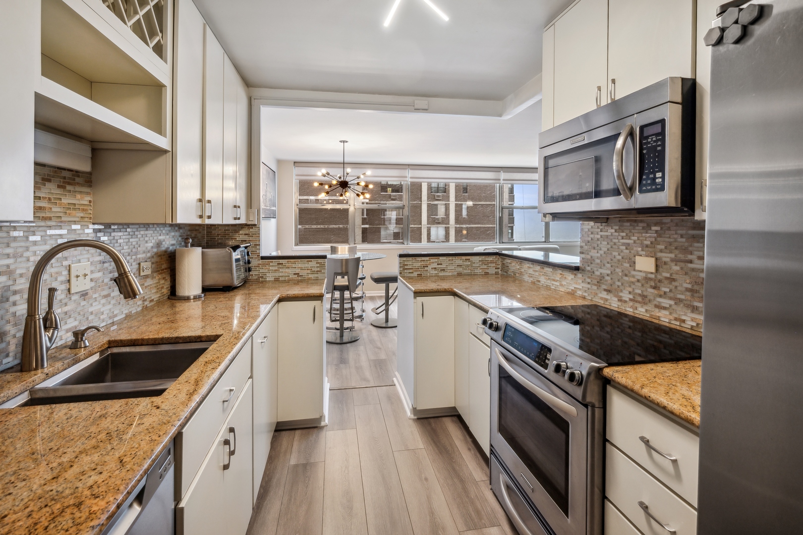 6301 North Sheridan Road, Unit 8E Chicago, IL 60660 - Photo 7 of 19 a kitchen with stainless steel appliances granite countertop a sink stove and refrigerator