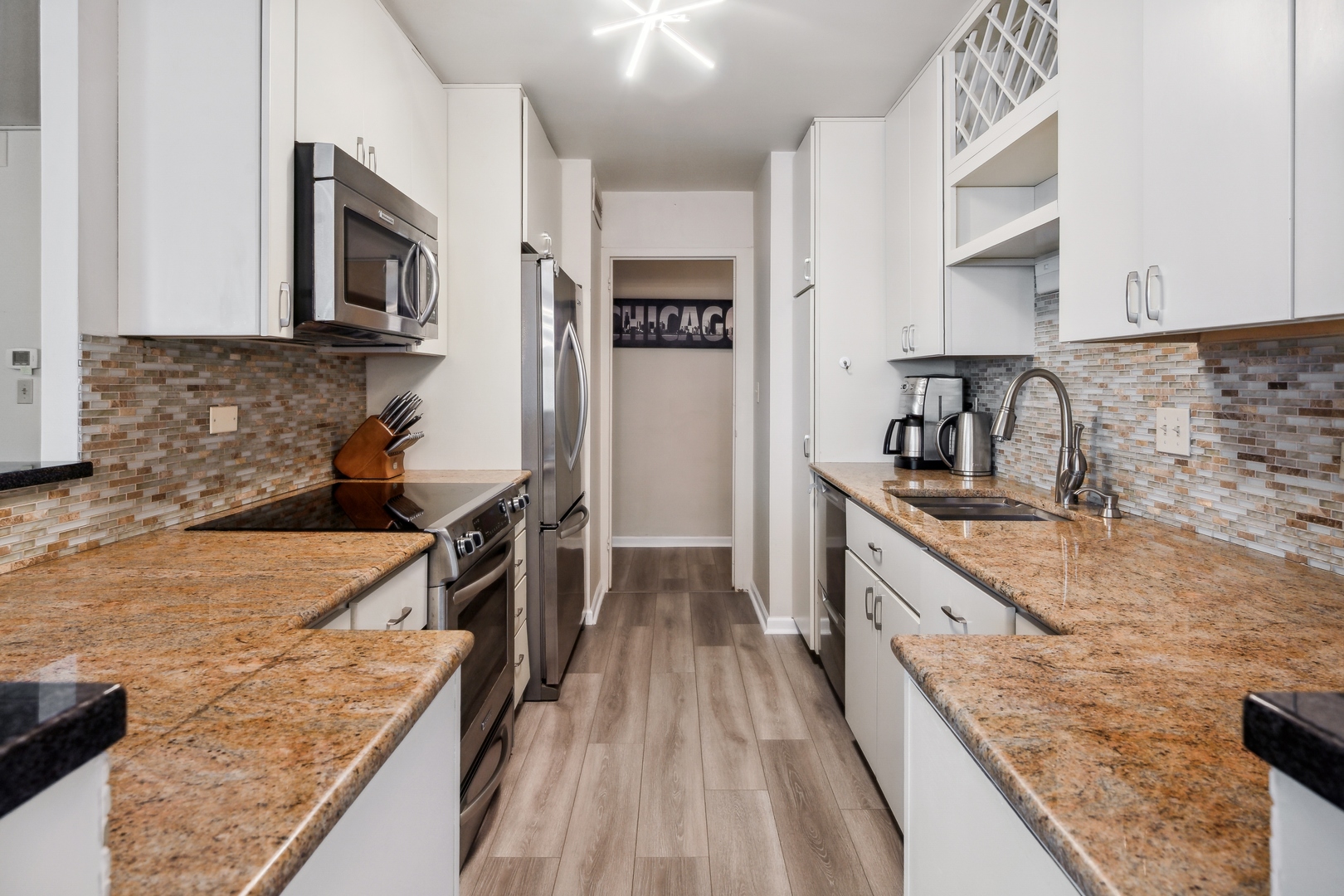 6301 North Sheridan Road, Unit 8E Chicago, IL 60660 - Photo 8 of 19 a kitchen with stainless steel appliances granite countertop a sink stove and refrigerator