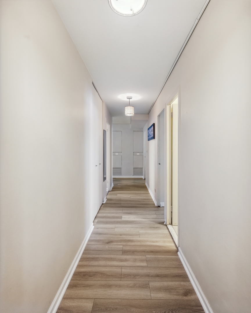 6301 North Sheridan Road, Unit 8E Chicago, IL 60660 - Photo 9 of 19 a view of a hallway with wooden floor and staircase