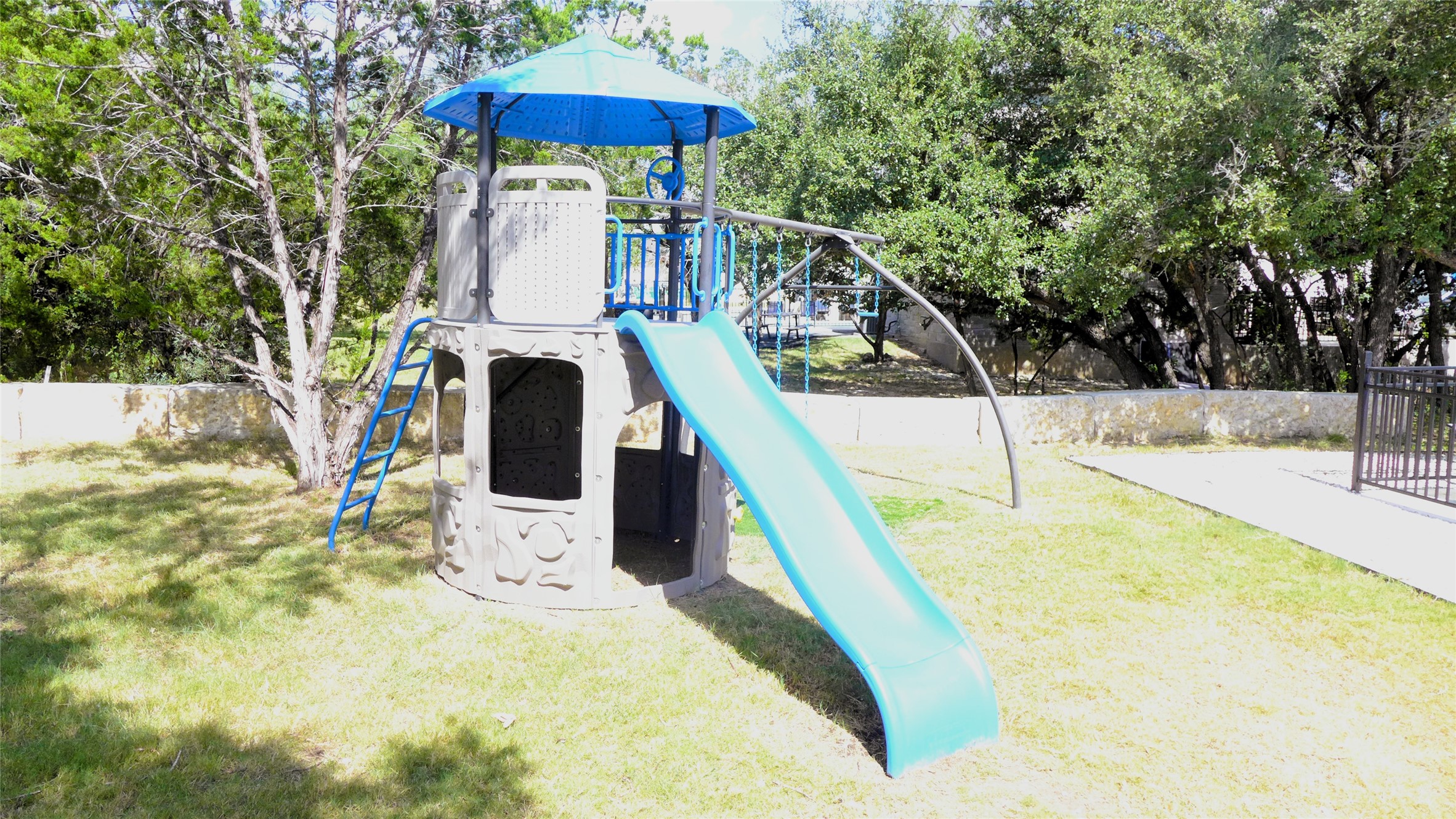 1718 Mountain Valley Road Concan, TX 78838 - Photo 37 of 40 Mature trees shade a spacious grassy backyard featuring a private play ground.